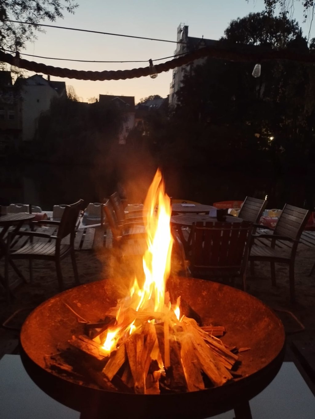 Lodernde Feuerschale auf der Terrasse bei Einbruch der Dämmerung