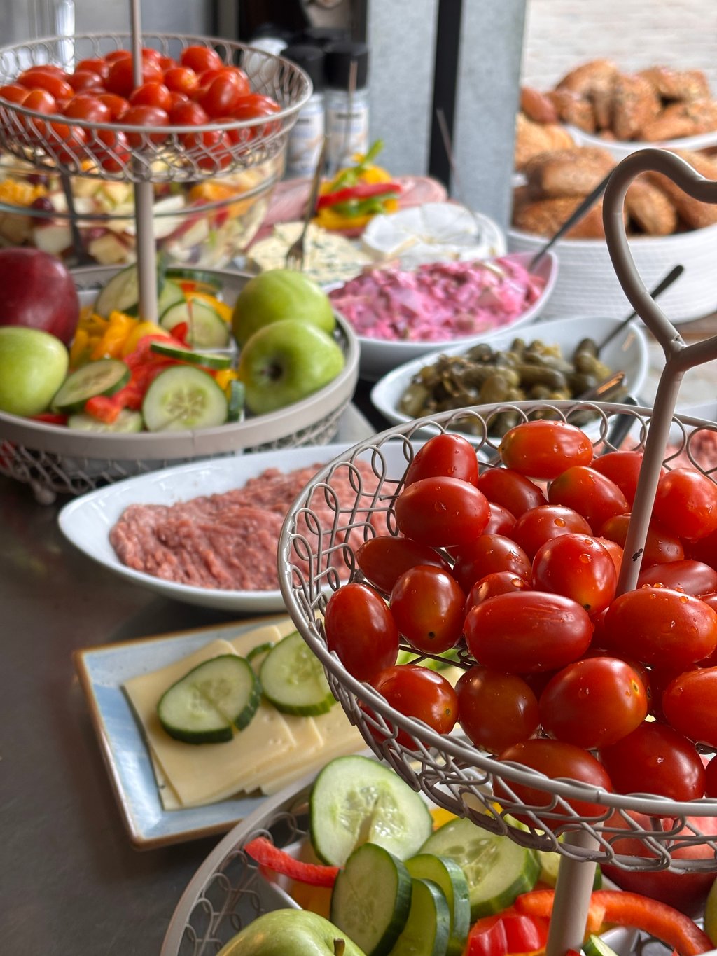 Buffet-Detail mit Antipasti, Käseplatte, Apfelspalten und Kirschtomaten