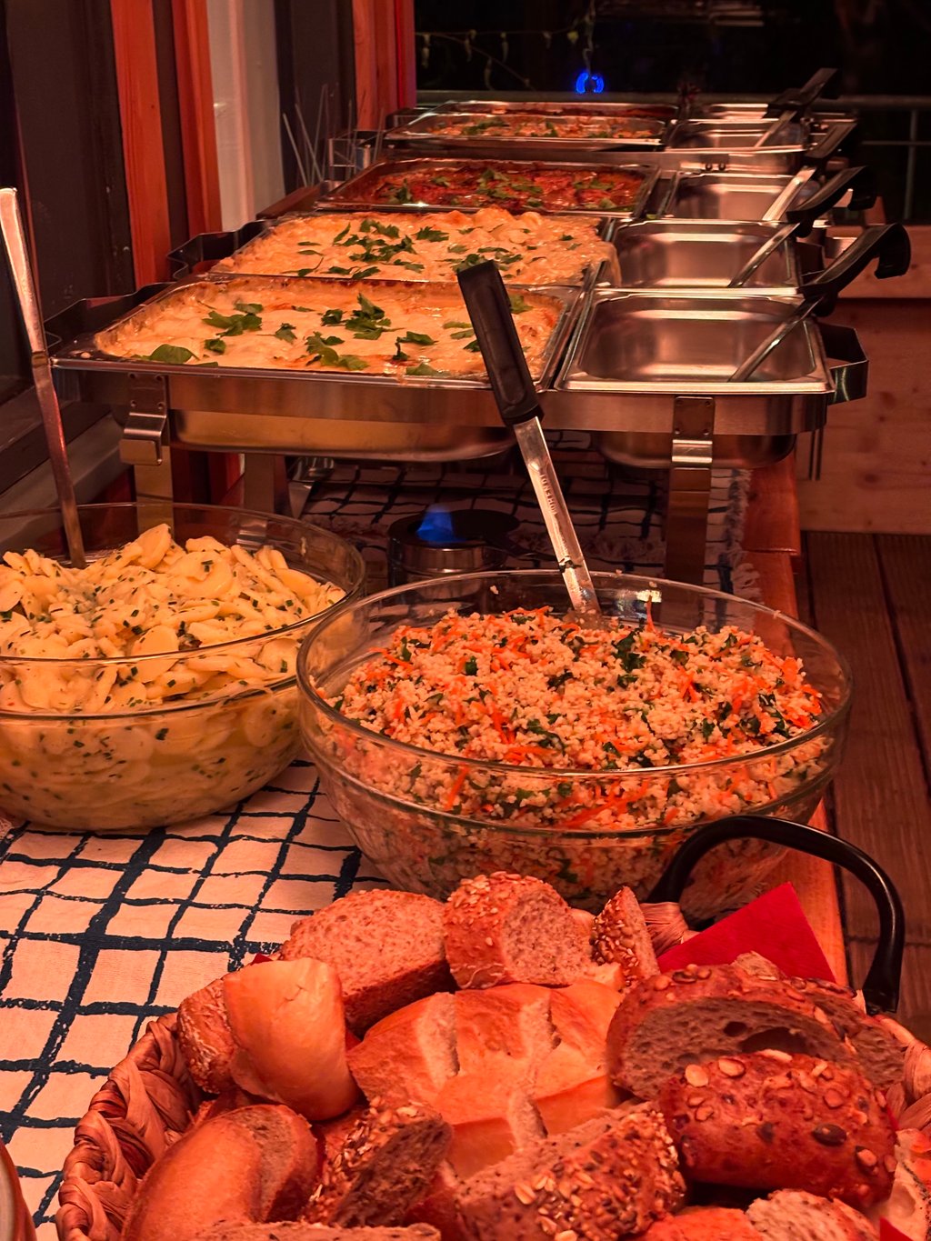 Reihe warmer Chafing Dishes mit Reis, Brot und Beilagen für ein Veranstaltungsbuffet